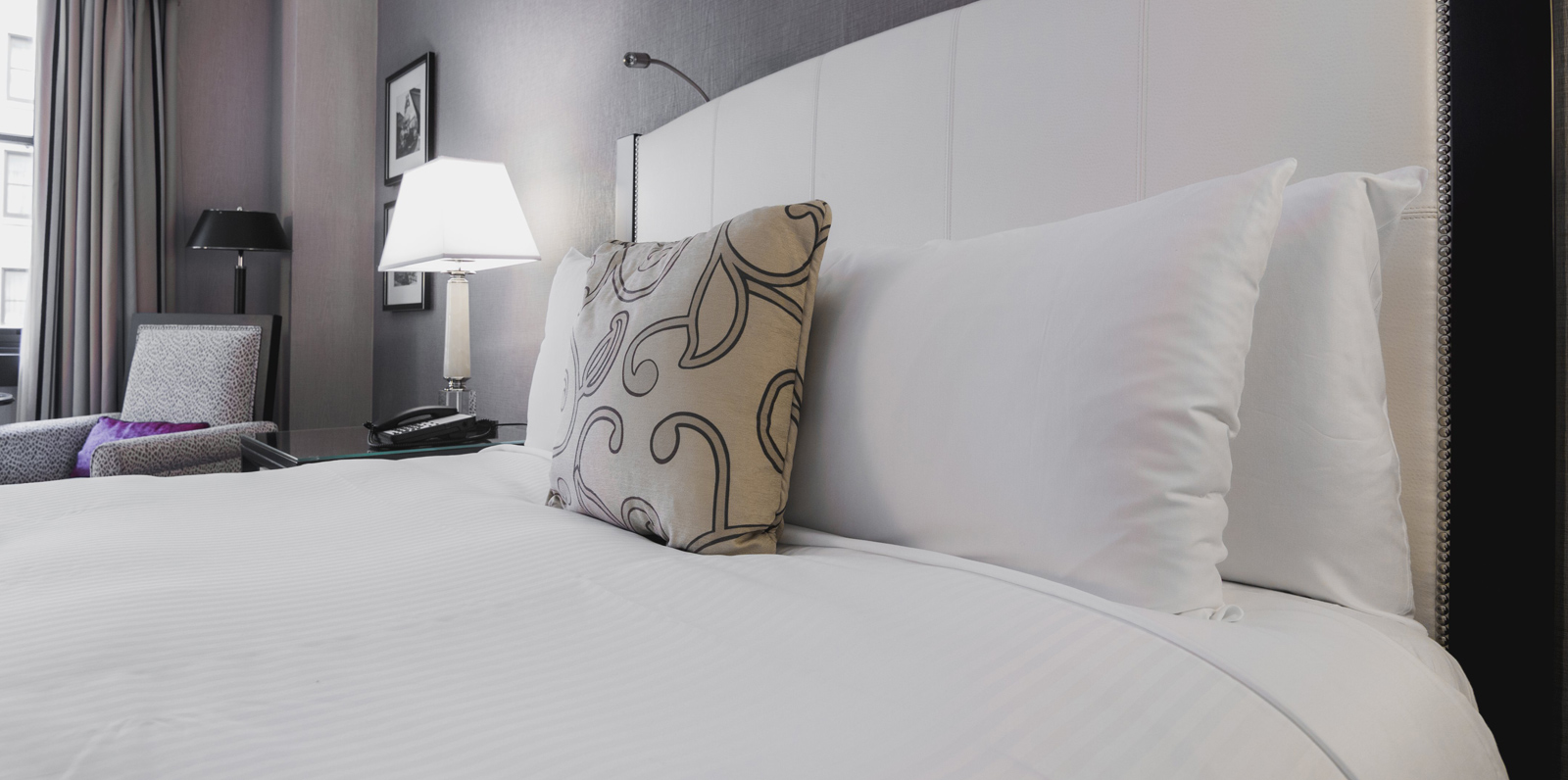 Photo d’ambiance d’une chambre confortable avec un grand lit et des oreillers